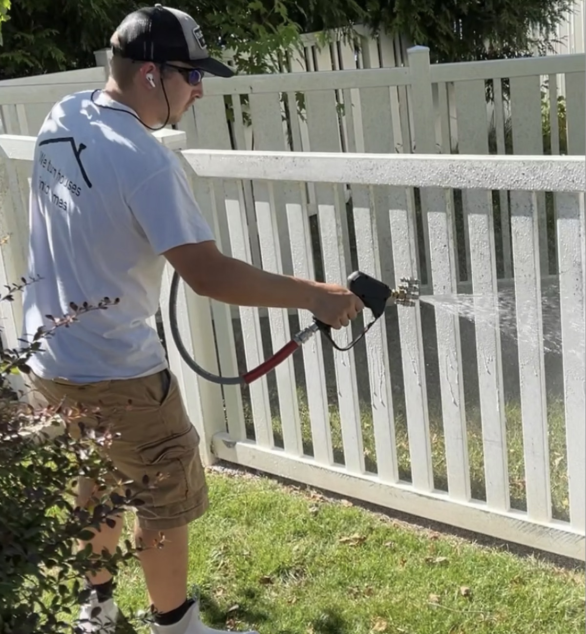 ATC technician washing a white vinyl fence